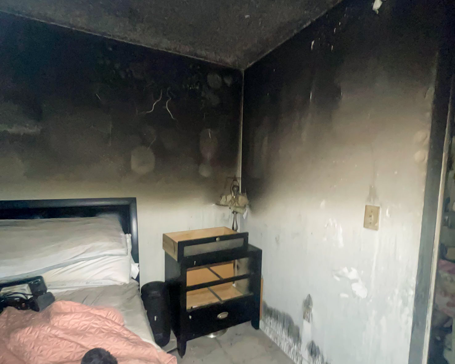 Smoke-damaged bedroom — soot on walls and ceiling