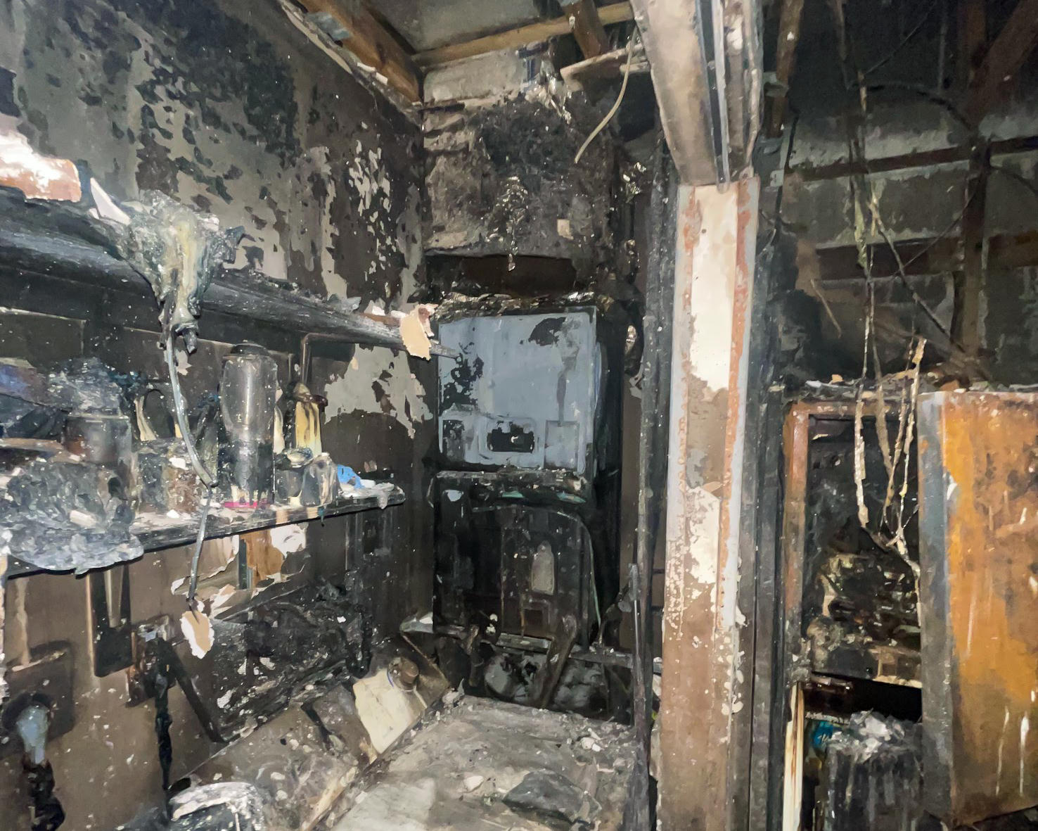 Completely burned interior room — debris and soot covering everything