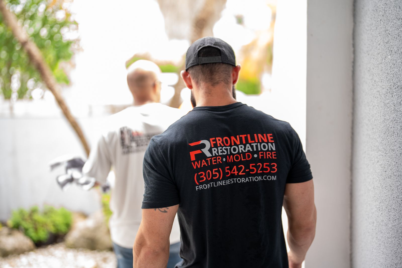 Frontline Restoration crew in branded shirts walking to a job