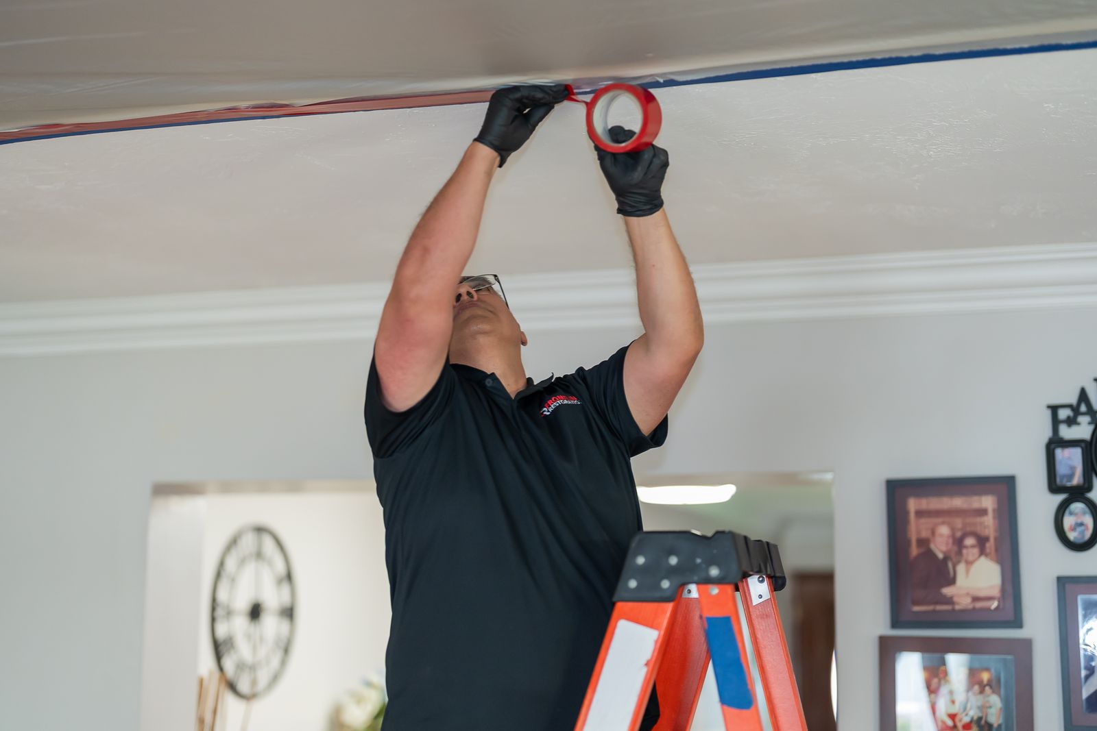 Technician on a ladder installing containment sheeting