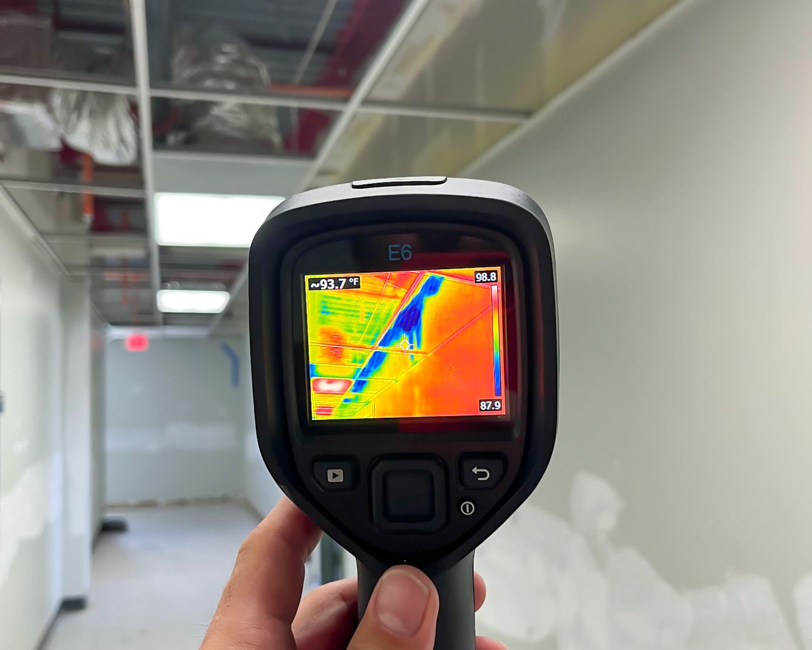 Thermal imaging camera used to scan a corridor for hidden moisture