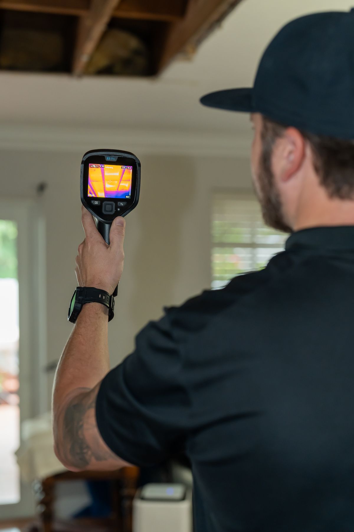 Technician scanning a ceiling with a thermal imaging camera