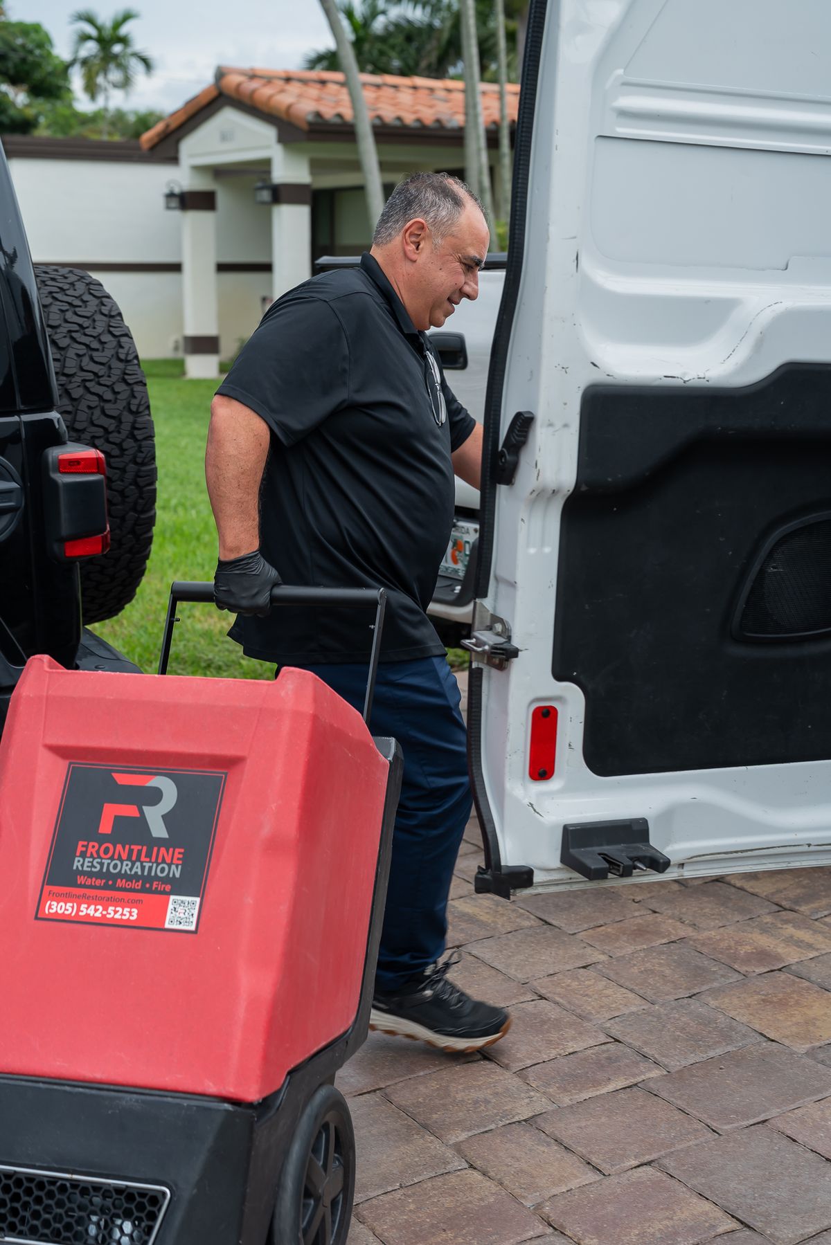 Equipment being unloaded from a Frontline Restoration van